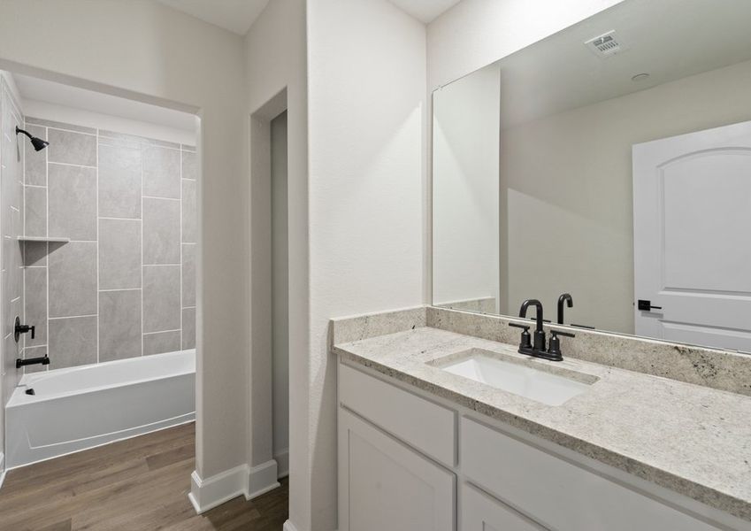 The secondary bathroom of the Noma has a large vanity space and a shower-tub combo.