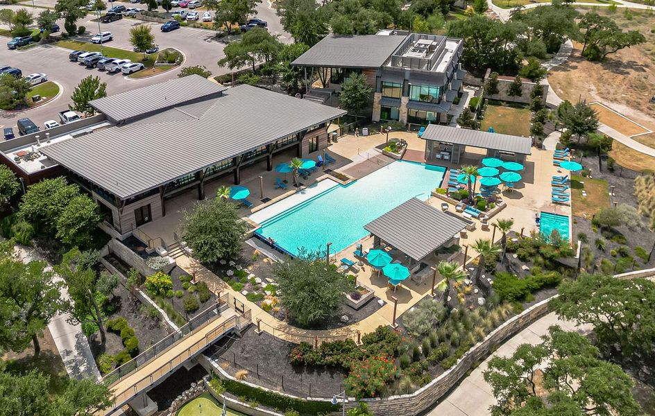 An aerial perspective reveals a sparkling outdoor pool and patio area amidst verdant landscaping, offering a tranquil community retreat. An aerial perspective reveals a sparkling outdoor pool and patio area amidst verdant landscaping, offering a tranquil community retreat.