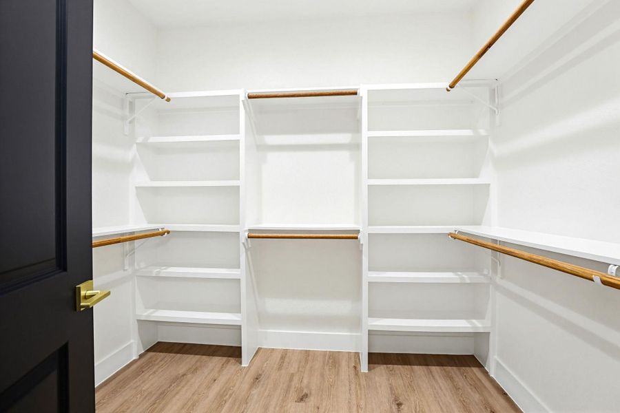 Ample shelving and hanging rods provide extensive storage in this well-appointed primary closet.