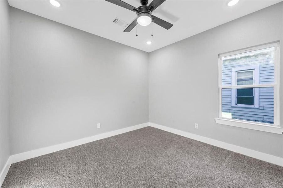 Carpeted spare room featuring ceiling fan