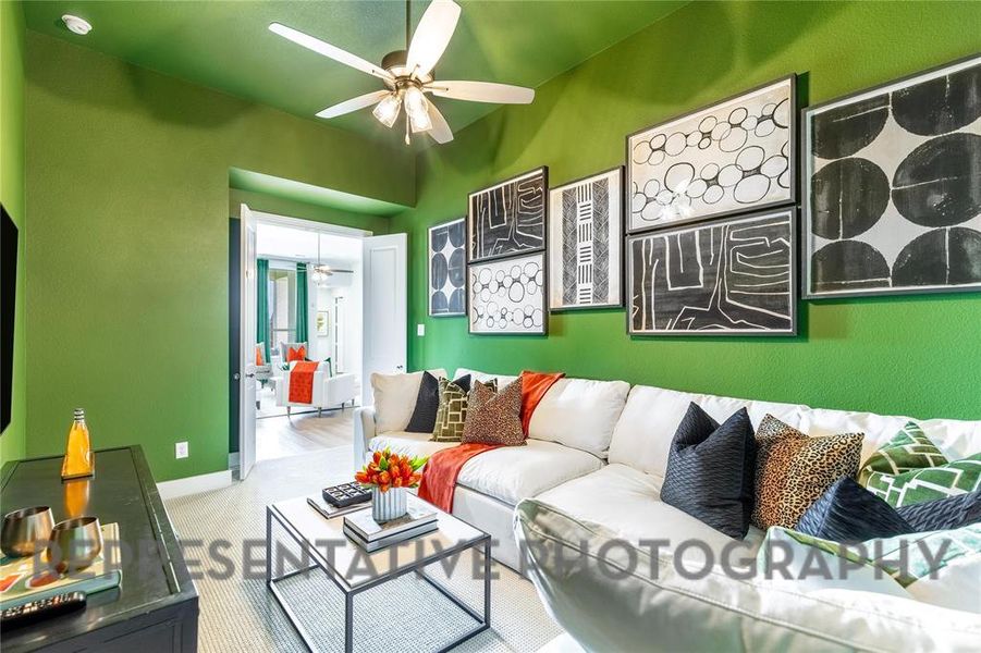 Carpeted living area with a ceiling fan and baseboards Carpeted living area with a ceiling fan and baseboards