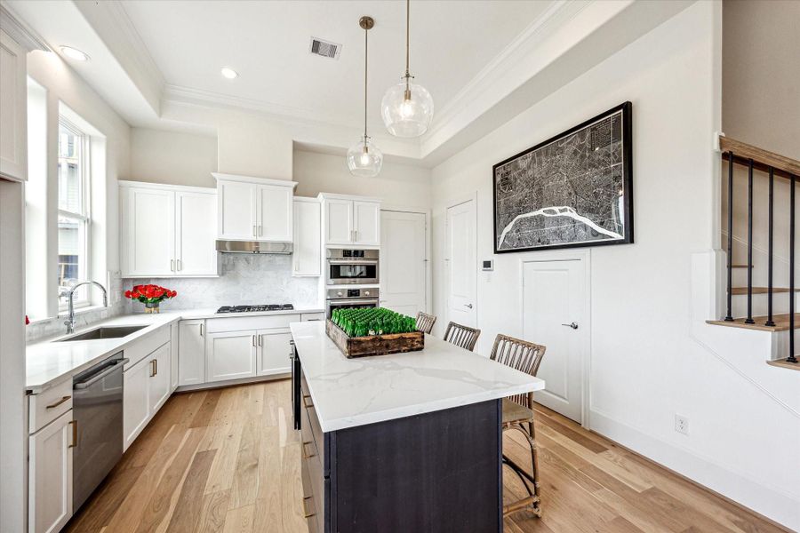 Luxe SS Bosch appliances and carrera white marble backsplash with gold hardware accents
