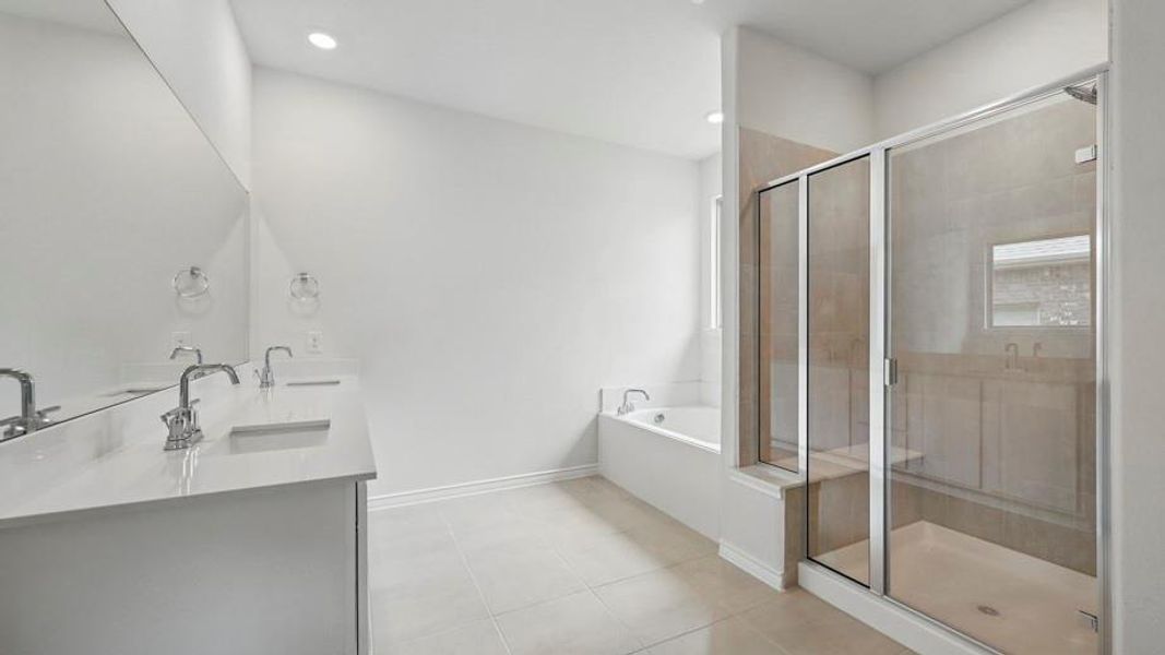 Bright bathroom featuring a dual vanity with undermount sinks and chrome fixtures, a built-in bathtub, and a glass-enclosed shower with a bench