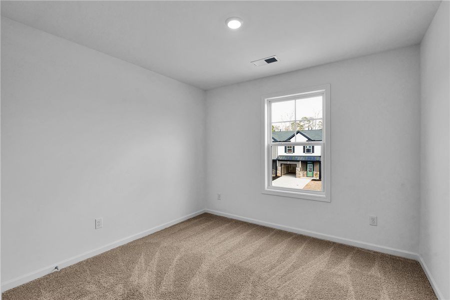 This cozy bedroom features plush carpeting and abu
