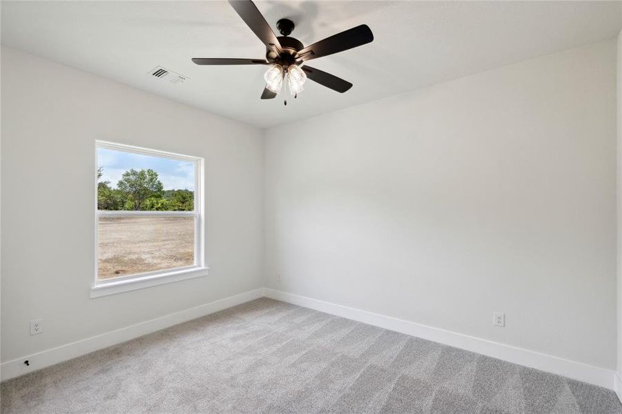 Carpeted empty room featuring ceiling fan