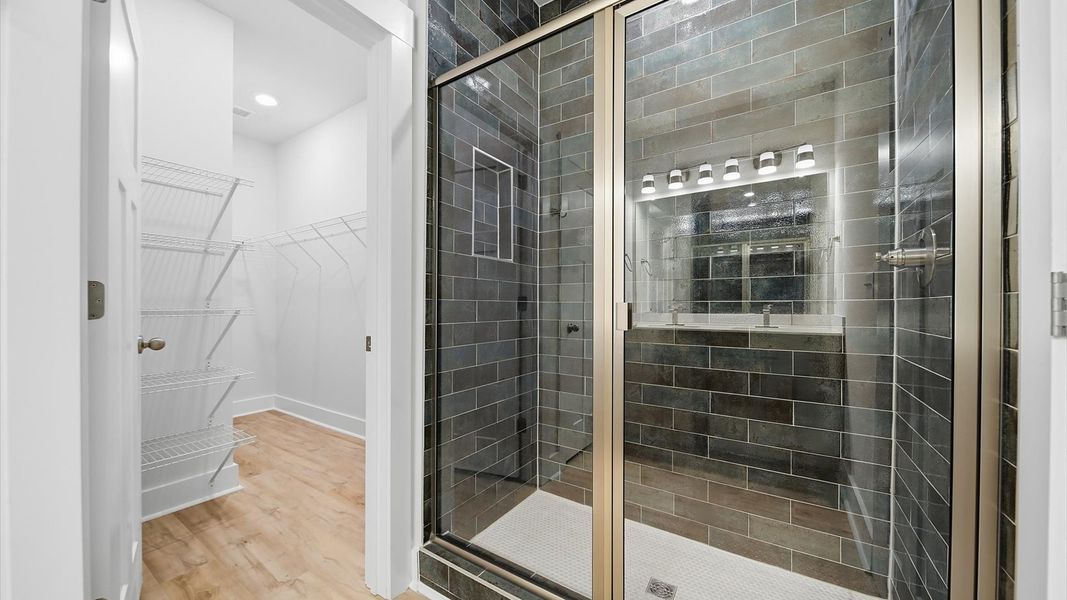 Elegant primary bathroom featuring a spacious walk-in shower and dual vanity in this first-class DRB Homes design Elegant primary bathroom featuring a spacious walk-in shower and dual vanity in this first-class DRB Homes design