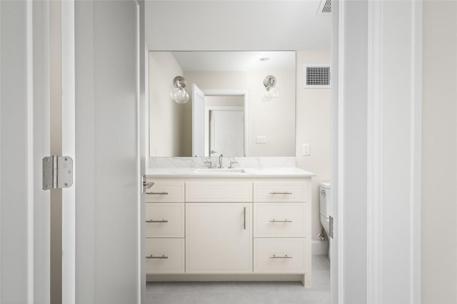 Well-appointed full bath on the third level with a spacious vanity and understated, refined finishes.