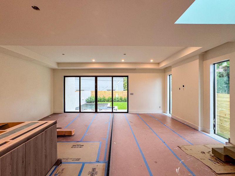 (as of April 8, 2026) looking out toward the backyard and pool area, the living room and dining spaces blend together beneath a tray ceiling