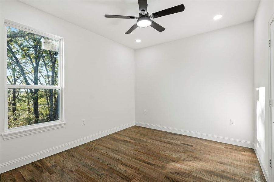Spare room with plenty of natural light, dark wood-style floors, a ceiling fan, and recessed lighting