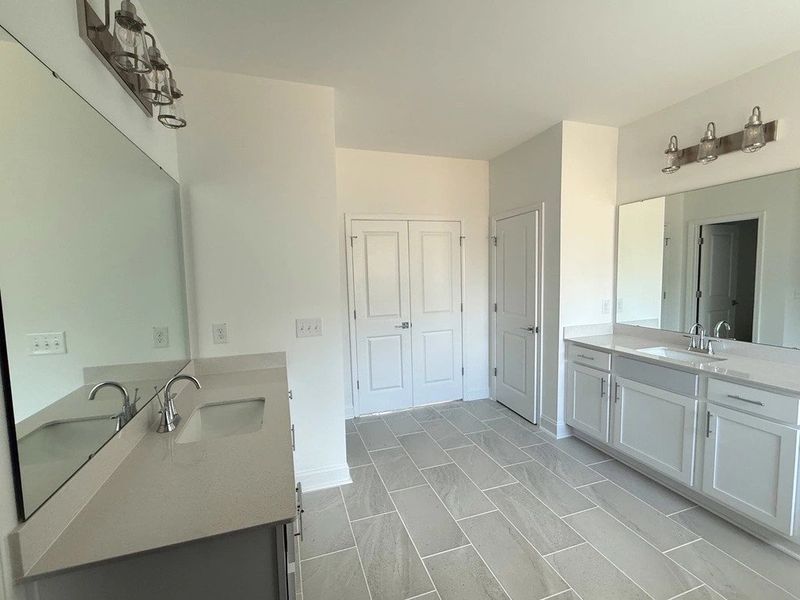 Primary Bath featuring the AW Collection® Coastal - Spa-like with white cabinets and light tile. Primary Bath featuring the AW Collection® Coastal - Spa-like with white cabinets and light tile.