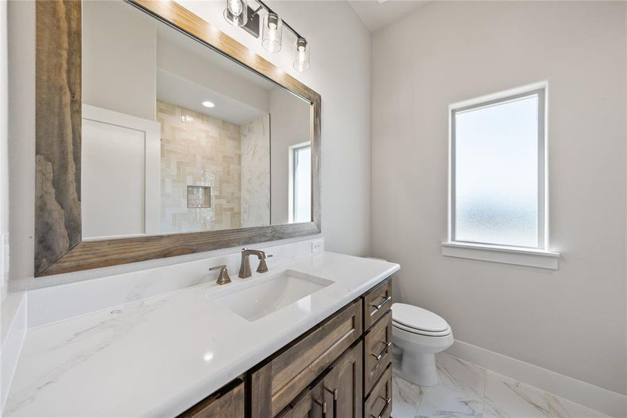 Bathroom with vanity, light marble finish flooring, and a shower