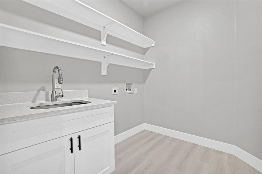 Laundry room with hookup for a washing machine, sink, light hardwood / wood-style flooring, and hookup for an electric dryer