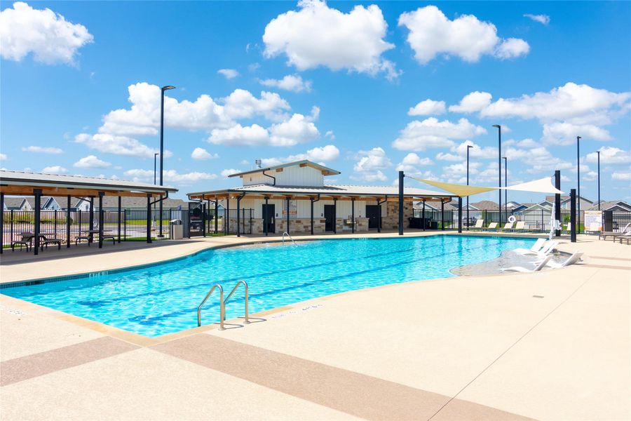 Community swimming pool with dedicated lap lanes, expansive deck space, and a shaded pavilion
