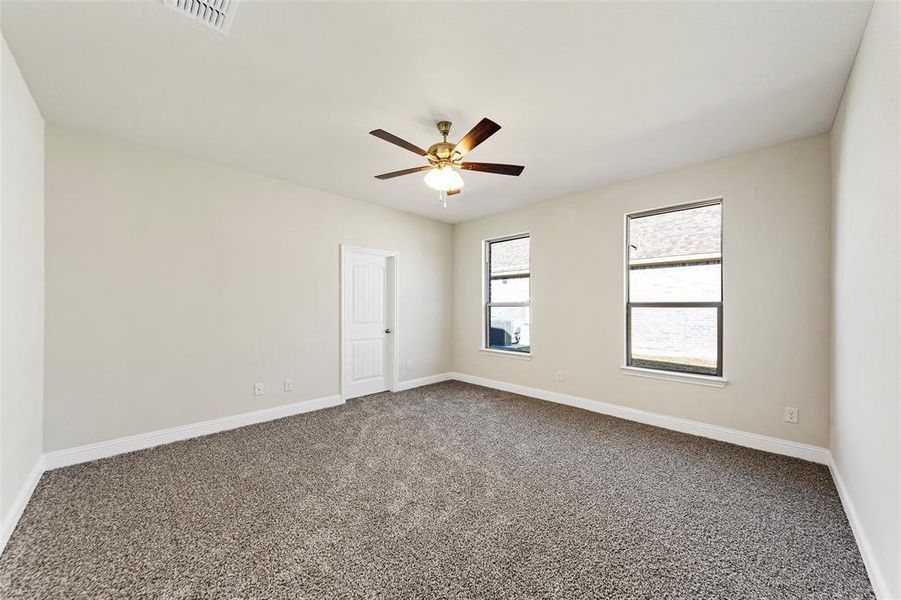 Carpeted spare room with ceiling fan