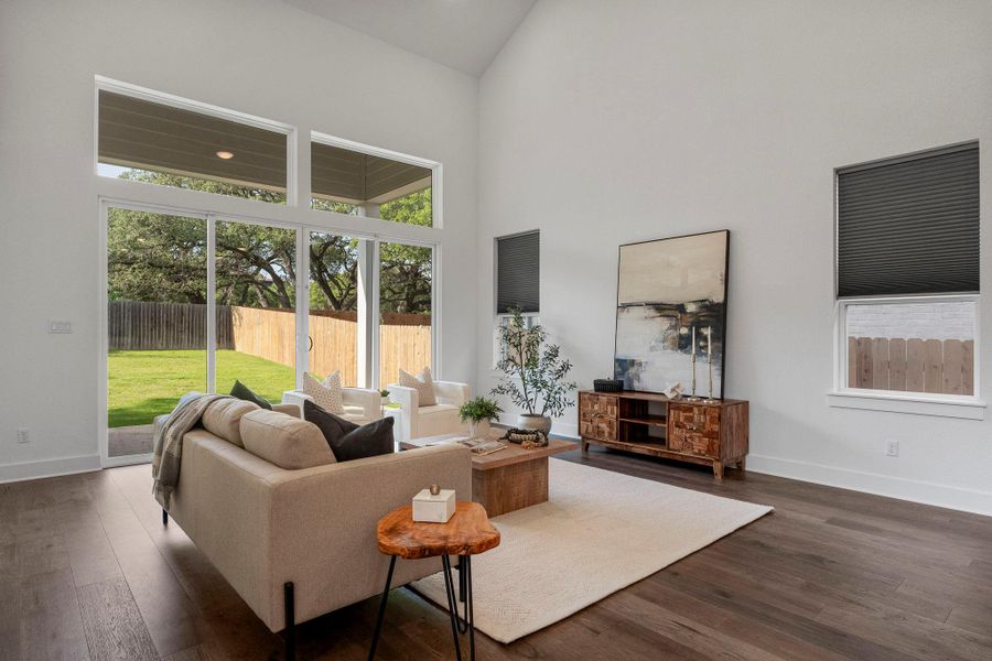 A welcoming living area boasts soaring vaulted ceilings and expansive glass sliding doors.