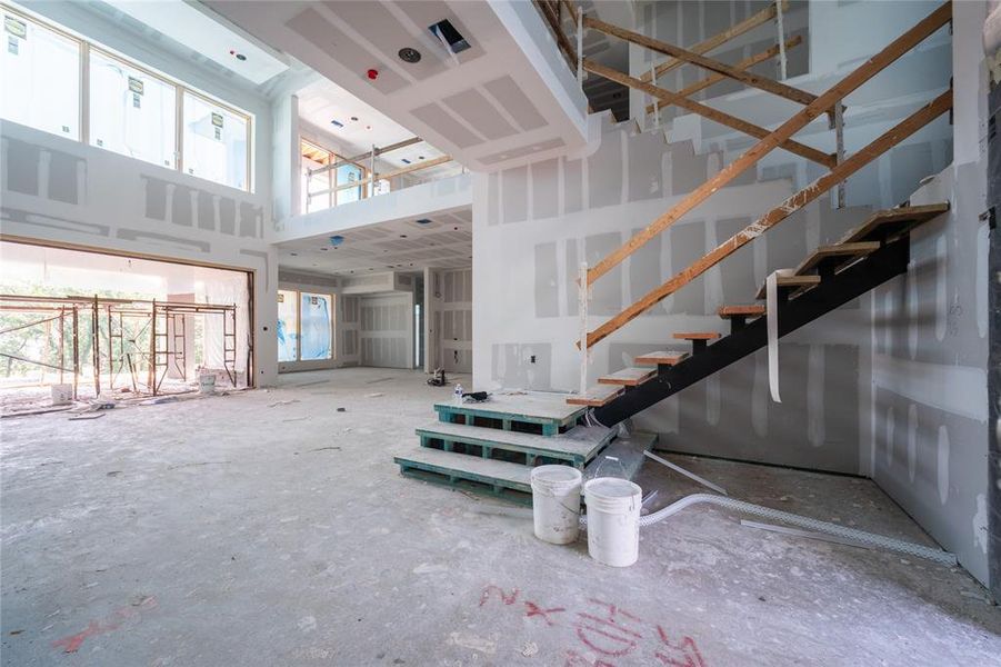 Entrance. Floating stairwell. Materials included are steel, wood, and glass.