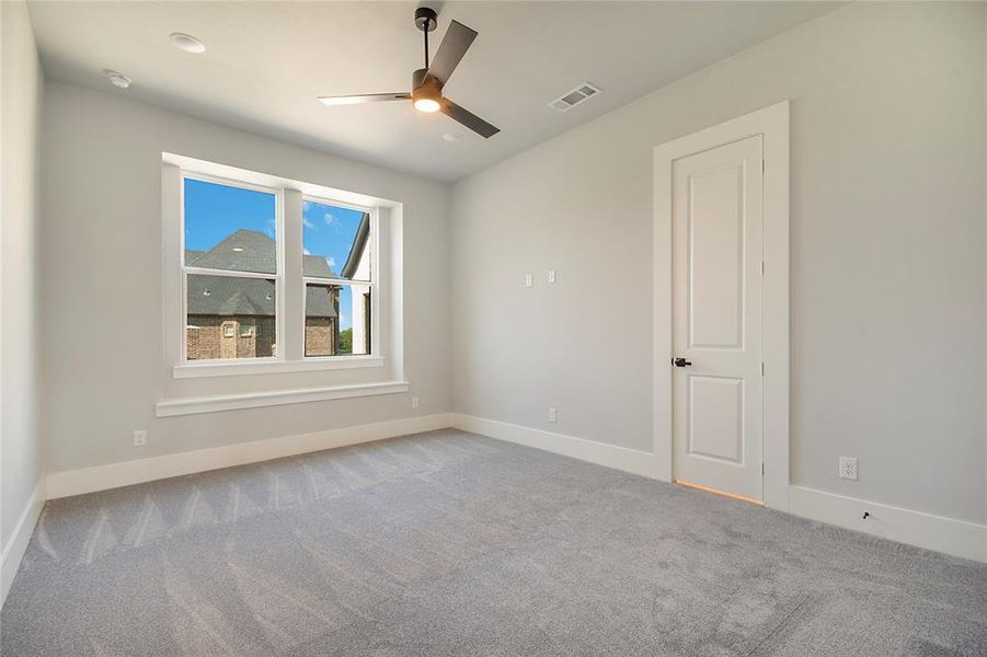 Carpeted empty room featuring baseboards and ceiling fan Carpeted empty room featuring baseboards and ceiling fan