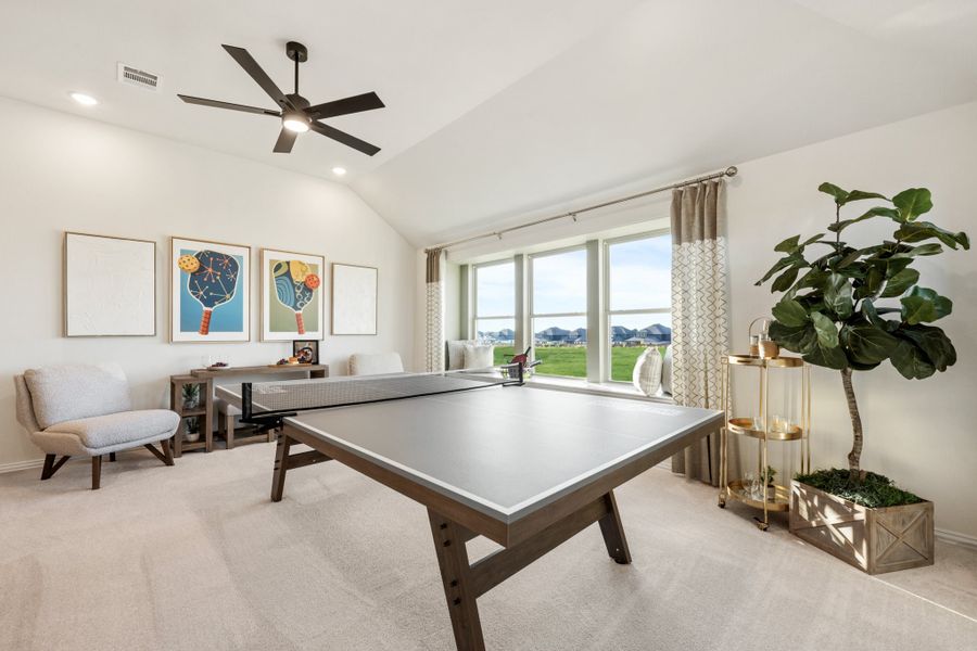 Game room with ping pong table, vaulted ceiling, ceiling fan, and large windows with outdoor views