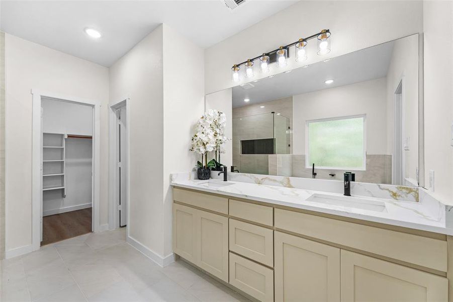 Dual vanity with light-toned cabinetry, integrated sinks, and polished countertops Dual vanity with light-toned cabinetry, integrated sinks, and polished countertops