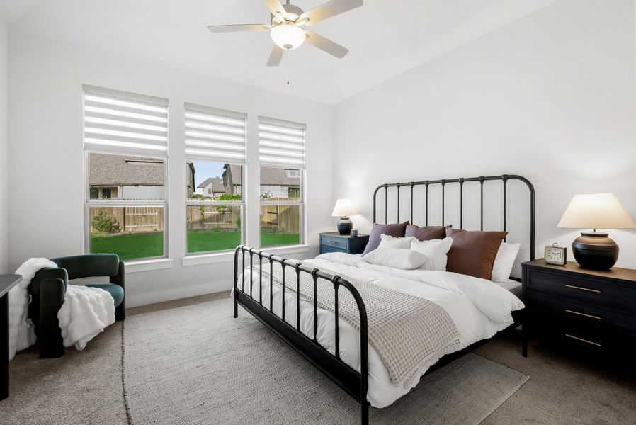 Natural light floods this inviting sleeping space, showcasing the neutral carpet and backyard views.