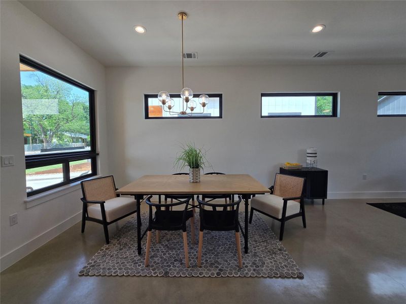Dining room featuring recessed lighting, baseboards, and finished concrete floors Dining room featuring recessed lighting, baseboards, and finished concrete floors