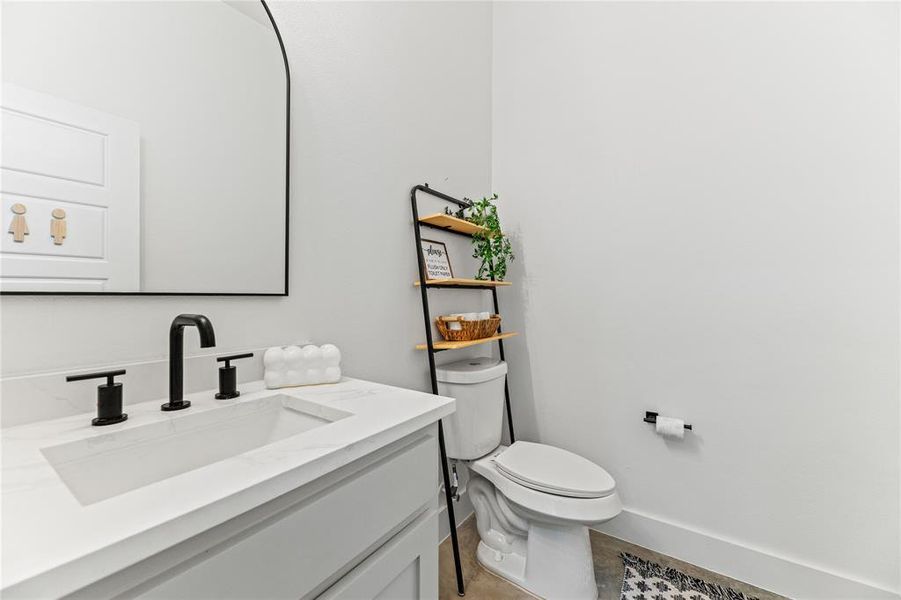 Half bathroom featuring vanity and toilet Half bathroom featuring vanity and toilet