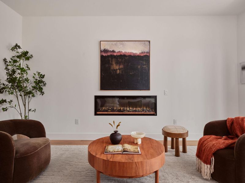 Living area featuring a glass covered fireplace and wood finished floors