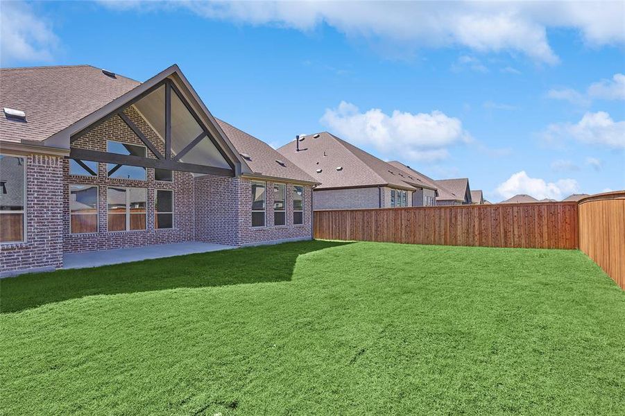 Rear view of house featuring a lawn and a patio