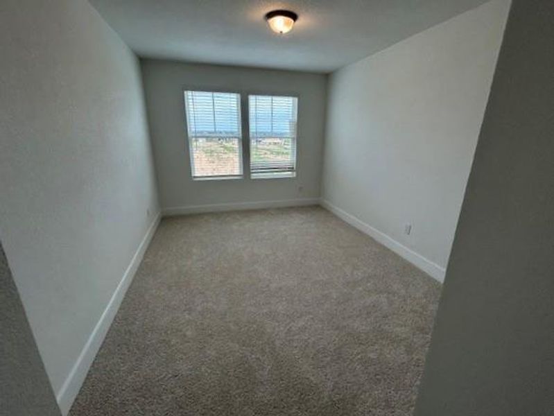 Empty room featuring baseboards and light carpet