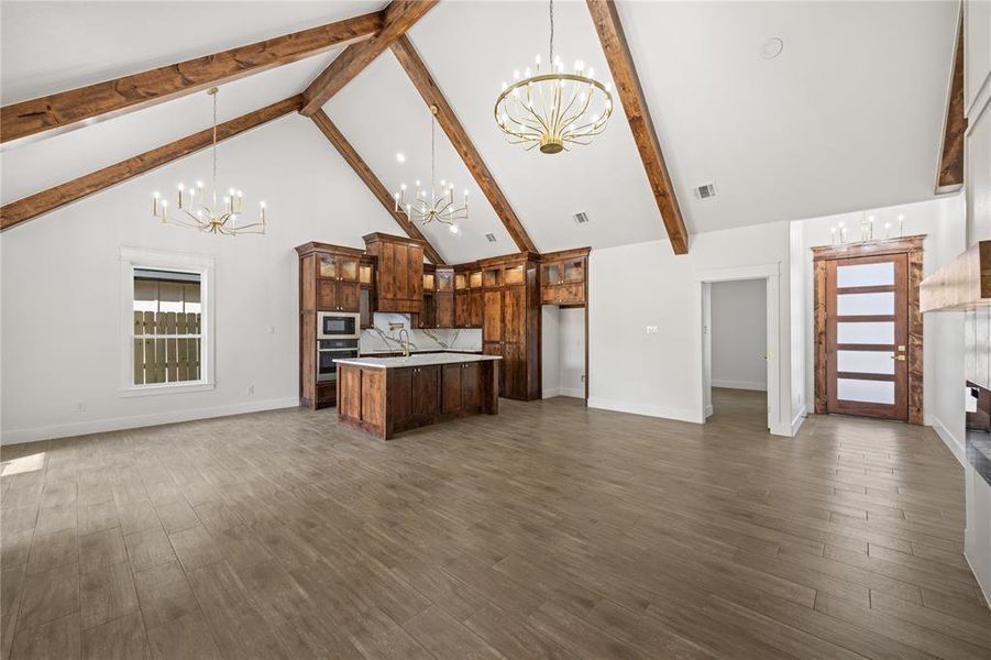 Kitchen featuring hanging lights, open floor plan, and glass fronted cabinets