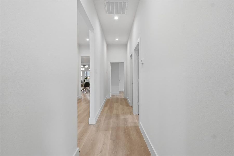 Corridor featuring light wood-type flooring and recessed lighting Corridor featuring light wood-type flooring and recessed lighting