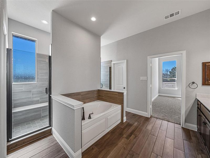 Prior listing photo. Property remains accurate - Full bathroom featuring vanity, a bath, a shower stall, dark wood-style flooring, and recessed lighting