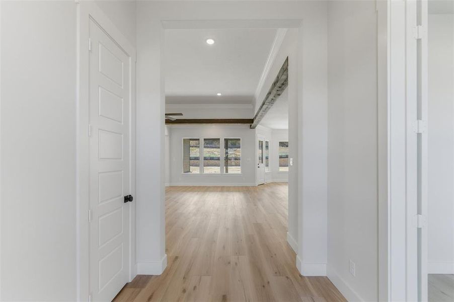Hallway with light wood-type flooring, recessed lighting, and ornamental molding
