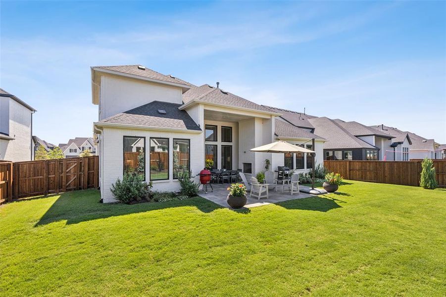 Rear view of property with a patio area and a yard