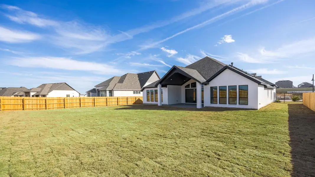 Rear view of house featuring a yard, a patio, a fenced backyard, and stucco siding
