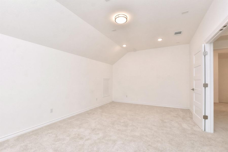 Additional living space with light colored carpet, lofted ceiling, and recessed lighting