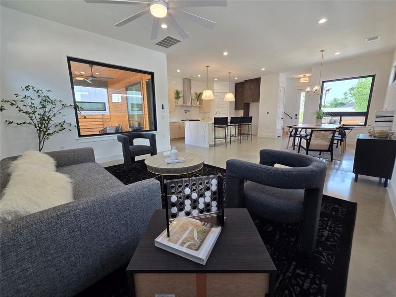 Living room featuring ceiling fan with notable chandelier, baseboards, visible vents, and recessed lighting Living room featuring ceiling fan with notable chandelier, baseboards, visible vents, and recessed lighting