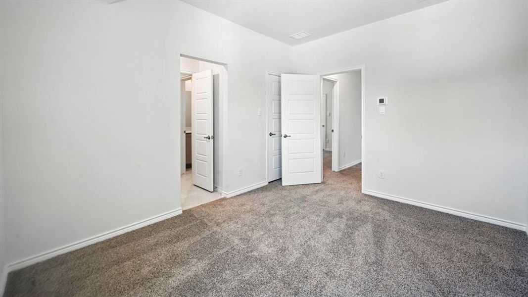 Unfurnished bedroom featuring light colored carpet and baseboards