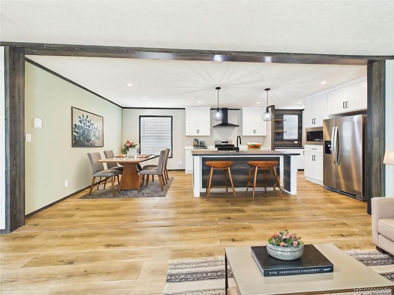 (Virtually Staged) Stylish kitchen featuring crisp cabinetry, modern finishes, and a functional island with seating for casual dining.