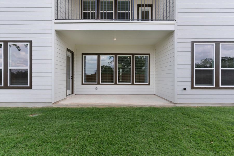 Property entrance featuring a patio, a yard, and board and batten siding