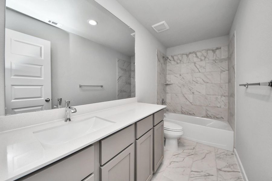 Secondary bedroom features plush carpeting, large windows that let in plenty of natural light, bright paint, and spacious closets. Sample photo of completed home with similar floor plan. Actual colors and selections may vary.
