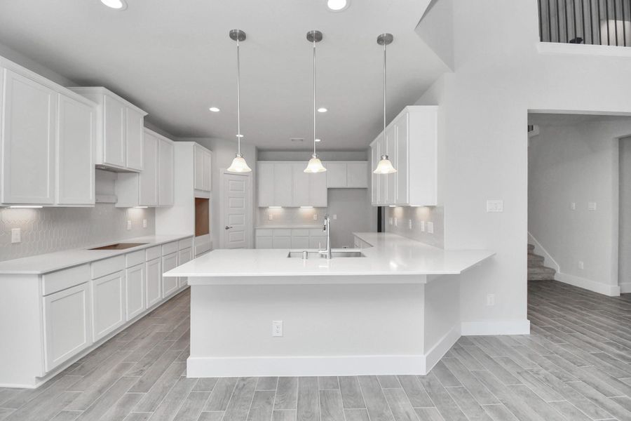 The kitchen is a culinary haven, featuring granite countertops, a tile backsplash, stainless steel appliances, 42” upper cabinets, and undercabinet lighting.