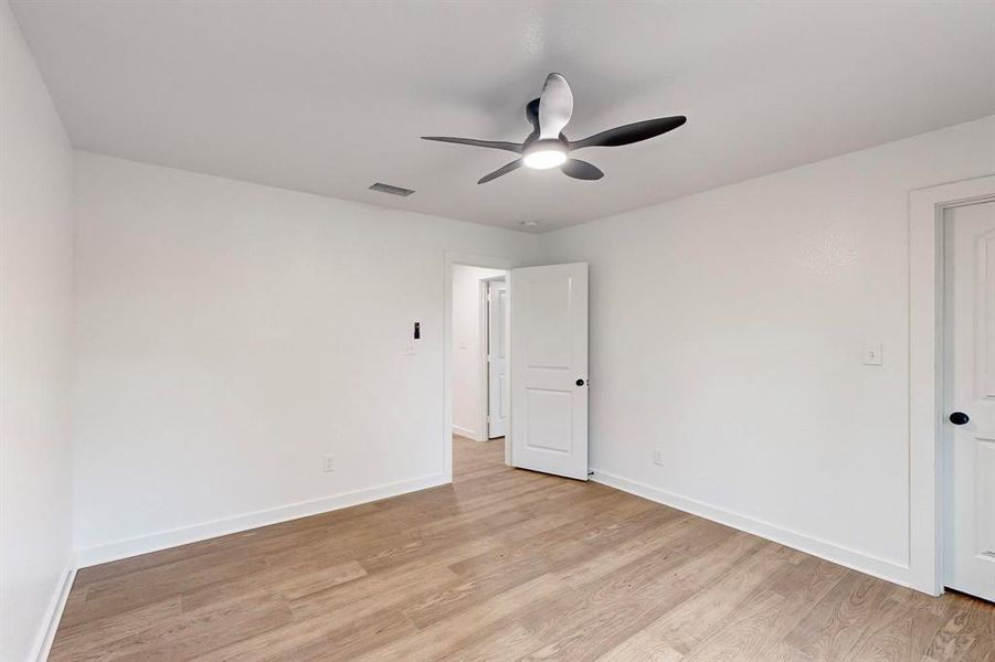 Unfurnished room featuring light wood-type flooring and ceiling fan