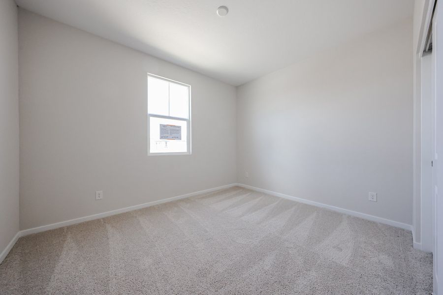 A room with a carpet and a window.