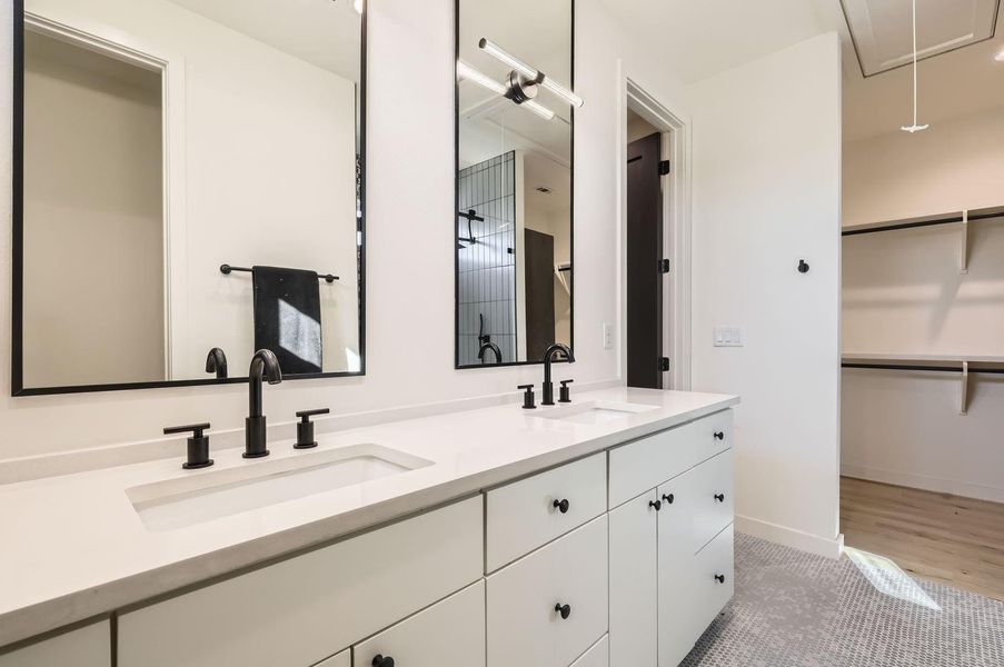 Elegant dual vanity with quartz countertop in the en-suite bath creates a luxurious, spa-like atmosphere.