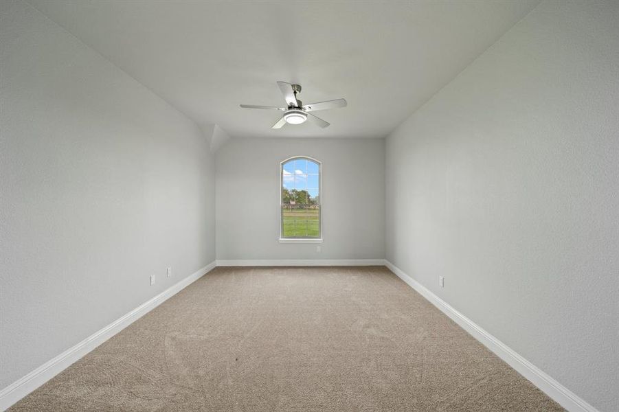 Carpeted empty room featuring ceiling fan