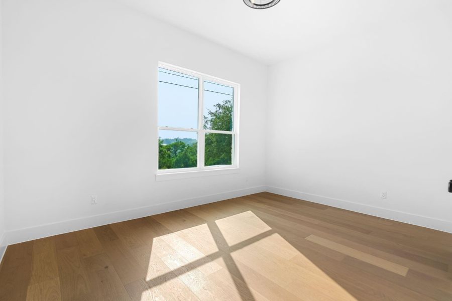 Unfurnished room featuring hardwood / wood-style floors Unfurnished room featuring hardwood / wood-style floors