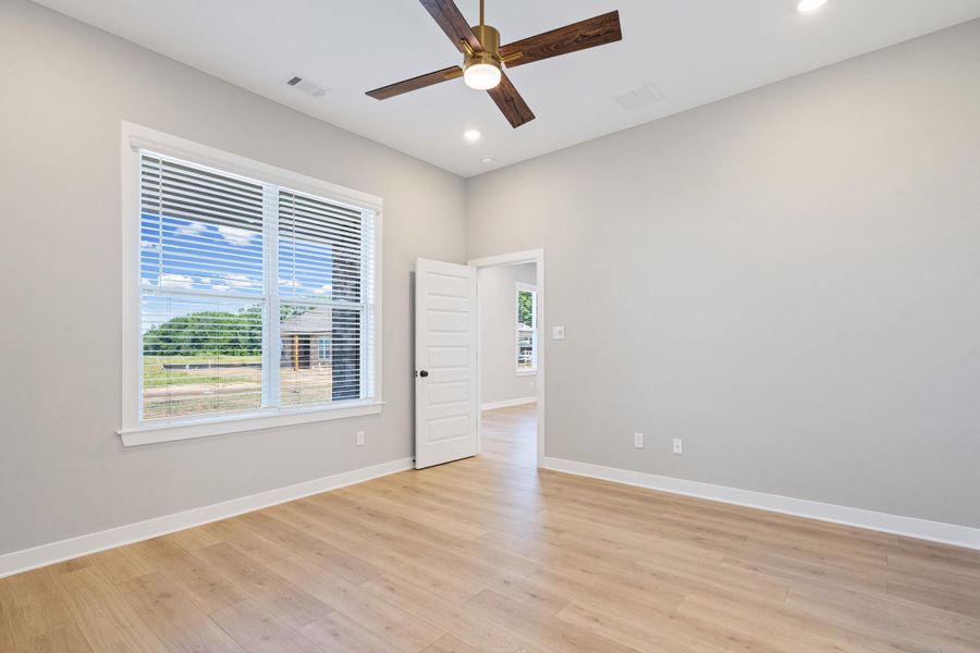 Room featuring wood-finish flooring, recessed lighting, and a ceiling fan with wooden blades
