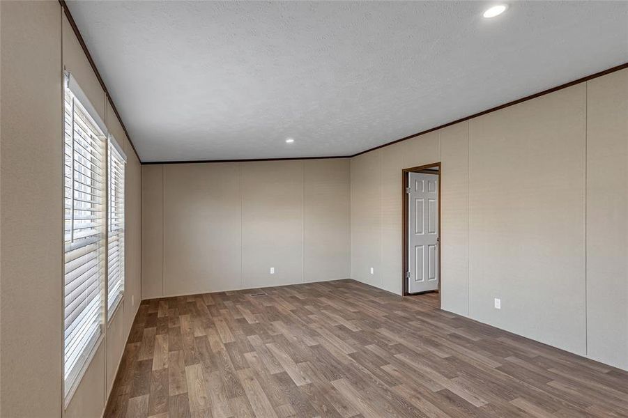 Unfurnished room featuring light wood-type flooring and crown molding