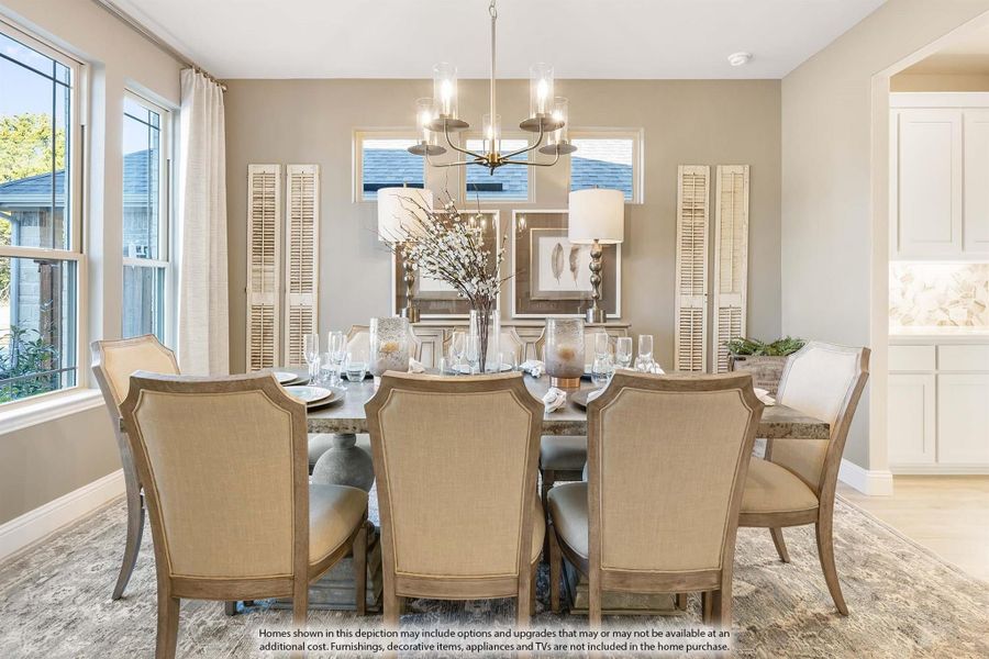 Formal dining room with large wooden table, upholstered chairs, and chandelier overhead